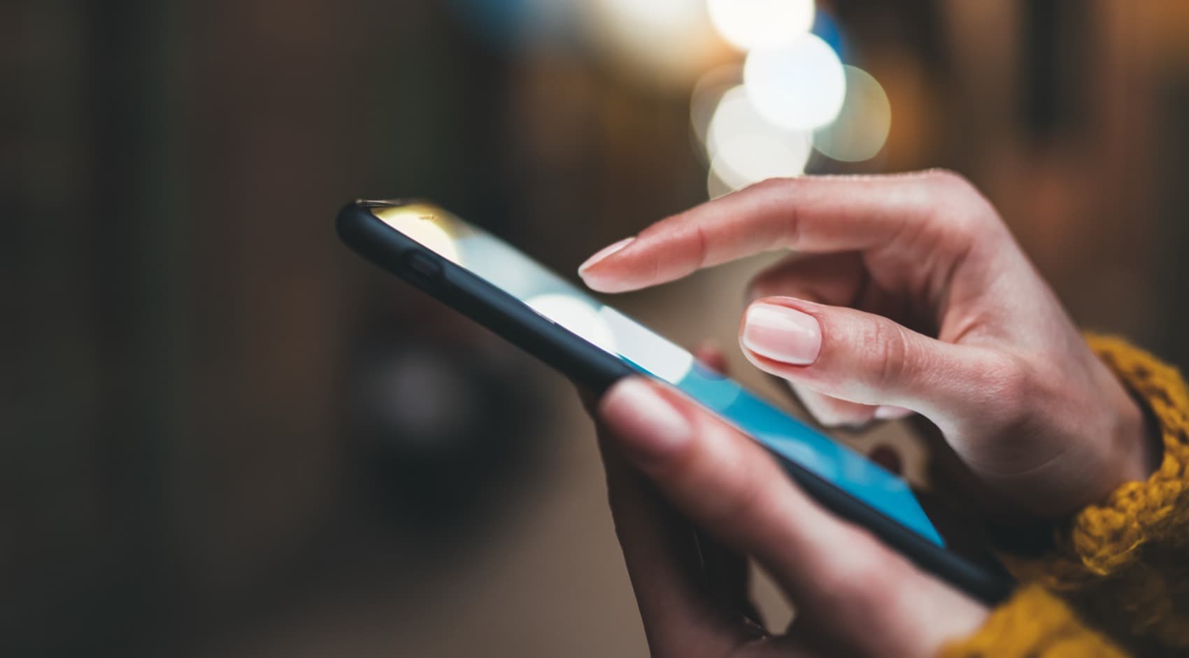 A person reading a warm message on their phone in the evening