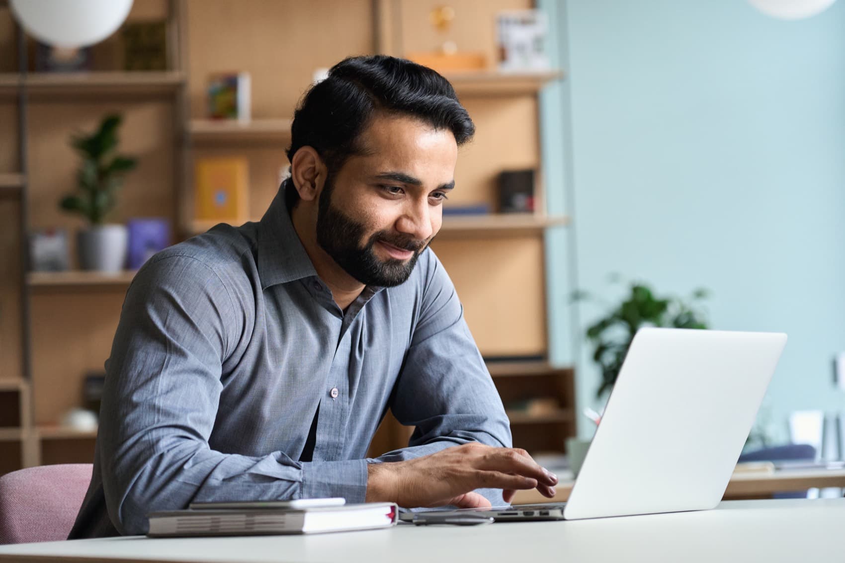 A pastor smiling while reviewing the week's content on a laptop